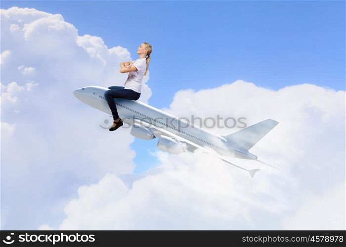Young woman riding drawn airplane flying in air. Woman ride airplane