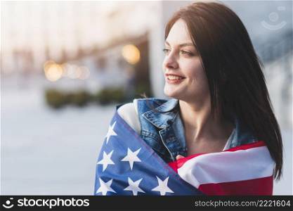 young woman rolling up american flag