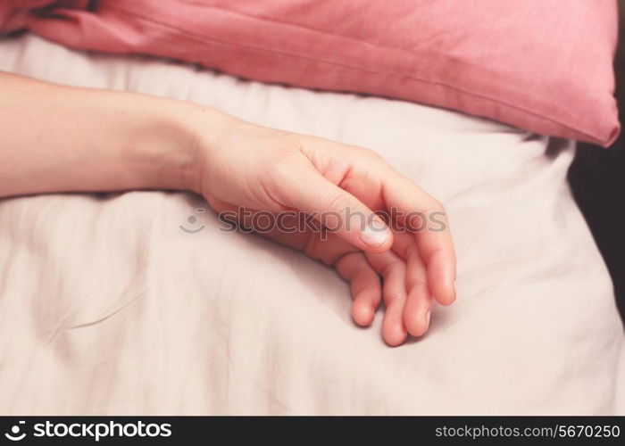 Young woman&rsquo;s arm in bed in the morning