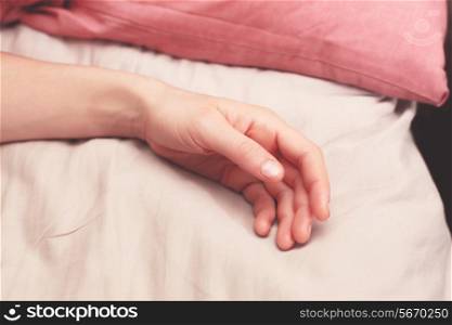 Young woman&rsquo;s arm in bed in the morning