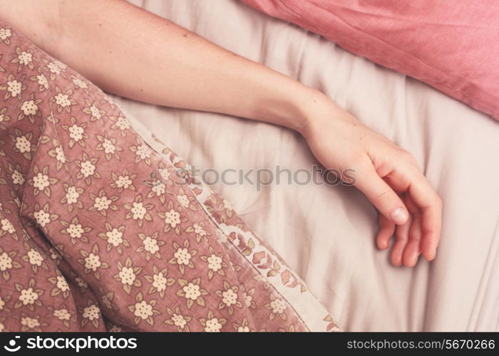 Young woman&rsquo;s arm in bed in the morning