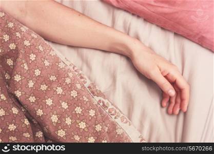 Young woman&rsquo;s arm in bed in the morning