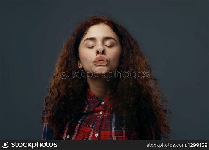 Young woman&rsquo;s crazy face crushed on transparent glass. Female person with pressed grimace standing at the showcase, humor, uncomfortable looking, facial fun