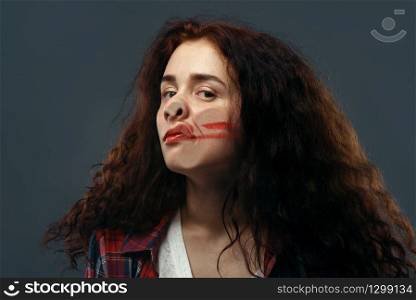 Young woman&rsquo;s face crushed on transparent glass, girl with smeared lipstick. Female person standing at the showcase with uncomfortable looking, humor, emotion expression