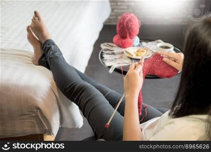 young woman&rsquo;s hands knitting warm sweaters. Sitting on old armchair near window, relaxing concept in her bedroom