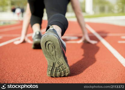 young woman runner getting ready run track
