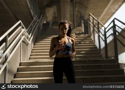 Young woman running alone down stairs  outdoor in urban environment