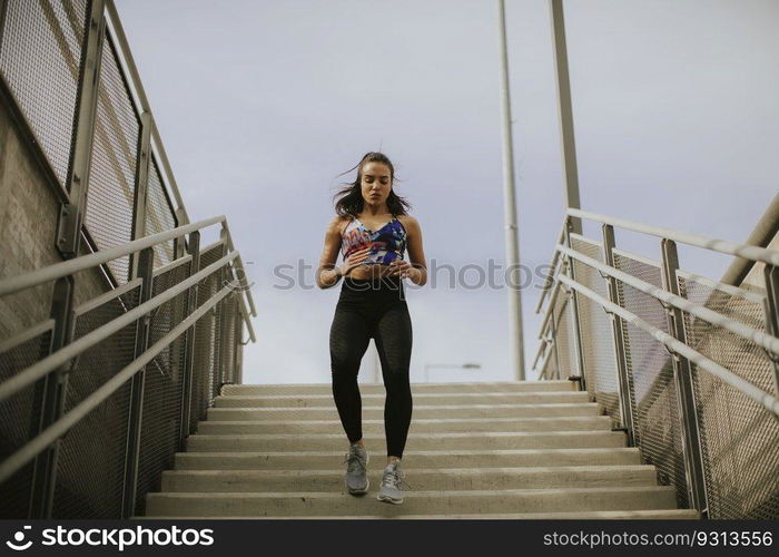 Young woman running alone down the stairs outdoor