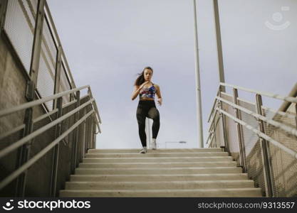 Young woman running alone down the stairs outdoor