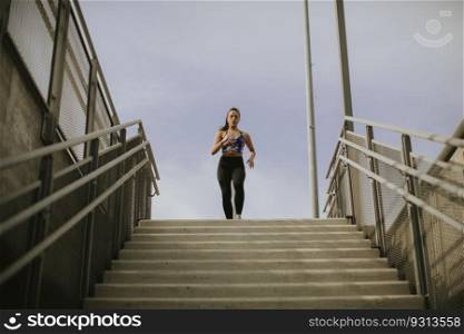 Young woman running alone down the stairs outdoor