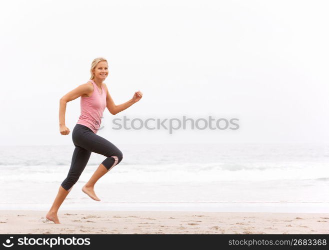 Young Woman Running Along Winter Beach