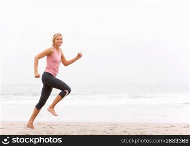 Young Woman Running Along Winter Beach
