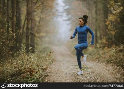 Young  woman running having exercise on the forest trail at autumn