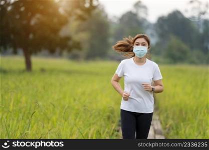 young woman running in field with medical mask to protect Coronavirus Covid-19  pandemic