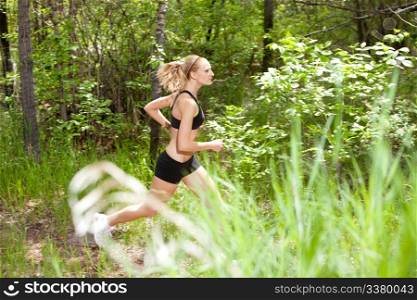 Young woman running in the forest on trail