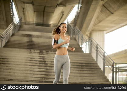 Young woman running in urban enviroment at sunny day