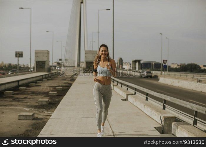 Young woman running in urban enviroment at sunny day