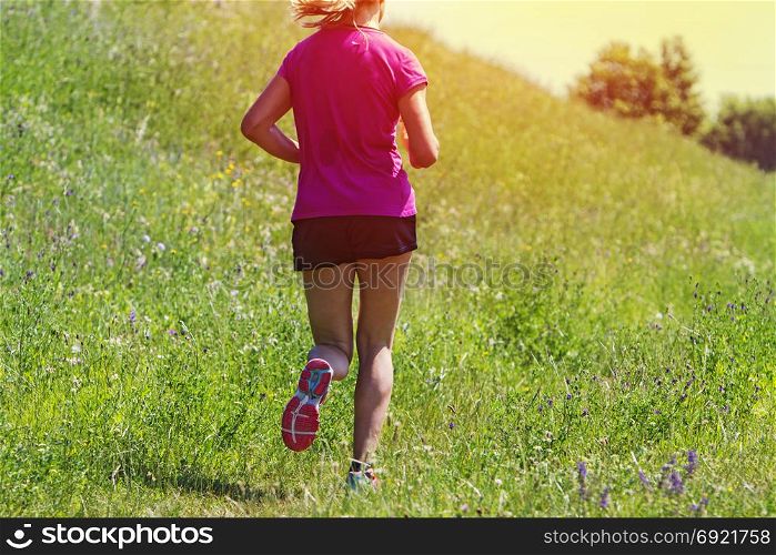 Young Woman running marathon outdoors in sunset