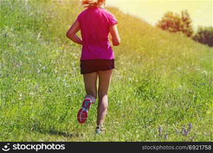 Young Woman running marathon outdoors in sunset