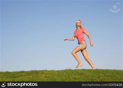Young woman running through field