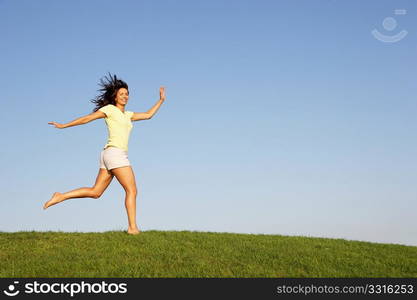 Young woman running through field