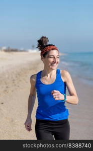 young woman runs on a seashore sandy beach in the morning