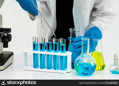 Young woman scientist working in chemical laboratory and examining biochemistry lab sample. Science technology medicine research and development study concept.