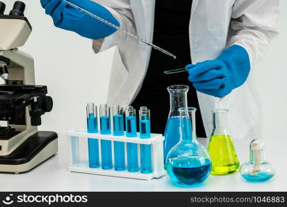 Young woman scientist working in chemical laboratory and examining biochemistry lab sample. Science technology medicine research and development study concept.