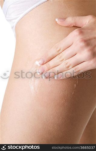 young woman scrubbing her legs with a beauty product