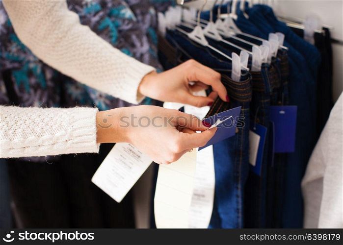 Young woman-seller glues prices the goods - kids clothes. Working days in shop