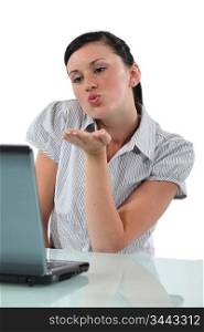 Young woman sending kisses through webcam