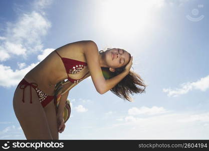 Young woman shaking hair on beach