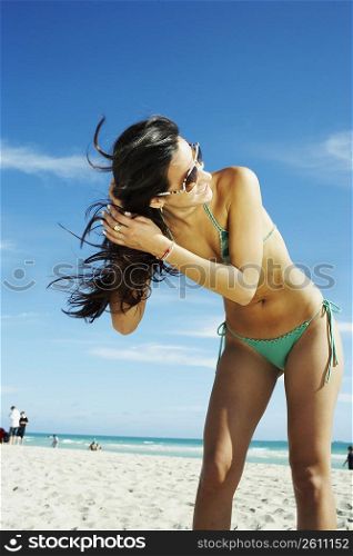 Young woman shaking hair on beach