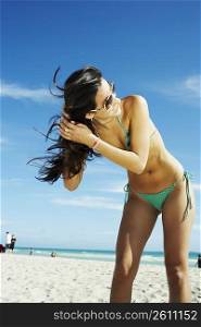 Young woman shaking hair on beach