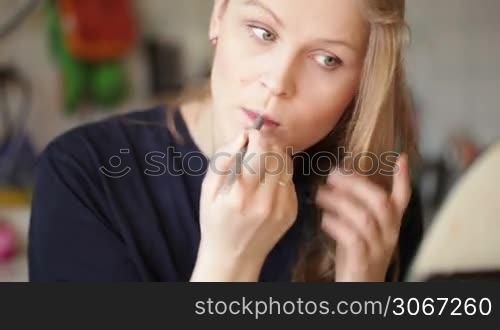 Young woman shaping her eyebrows. Close up portrait with natural morning sunlight.