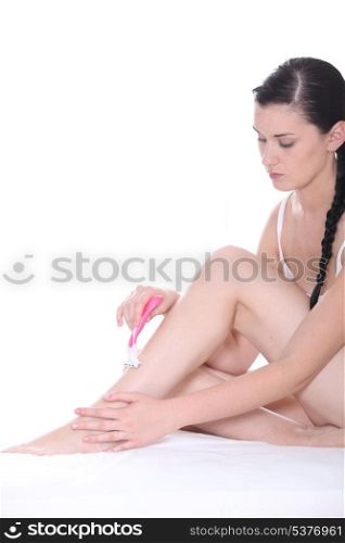 Young woman shaving her legs