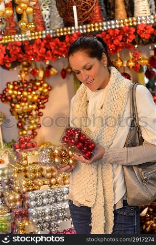 Young woman shopping christmas balls in shop