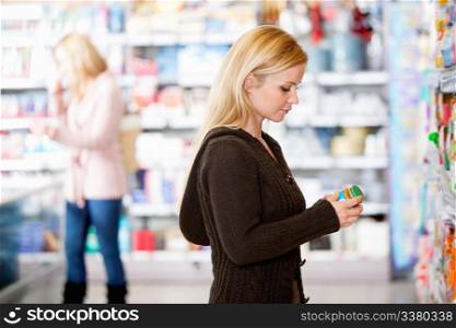 Young woman shopping in the supermarket with people in the background