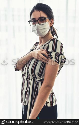 Young woman showing COVID-19 vaccine bandage merrily in concept of coronavirus vaccination program to vaccinate citizen .. Young woman showing COVID-19 vaccine bandage merrily