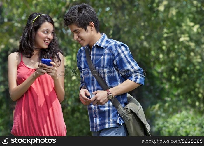 Young woman showing her cell phone to her friend