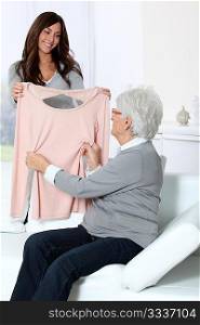 Young woman showing new clothes to grandmother