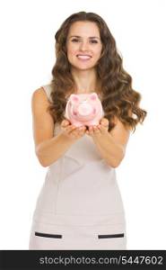 Young woman showing piggy bank