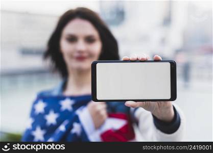 young woman showing smartphone with blank screen