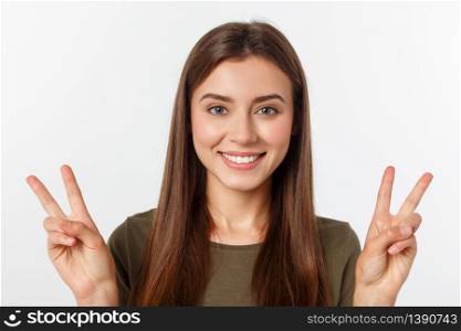 Young woman showing two fingers, positive or peace gesture, on white. Young woman showing two fingers, positive or peace gesture, on white.