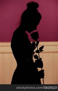 Young woman silhouette holding rose