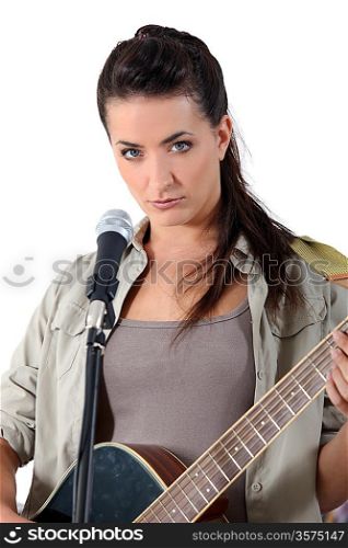 young woman singing and playing guitar