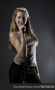 Young woman singing in studio