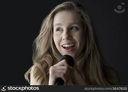 Young woman singing into microphone, close-up