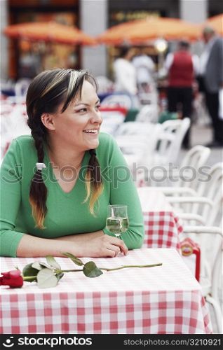 Young woman sitting at a sidewalk cafe
