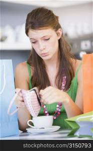 Young woman sitting at a table checking change purse